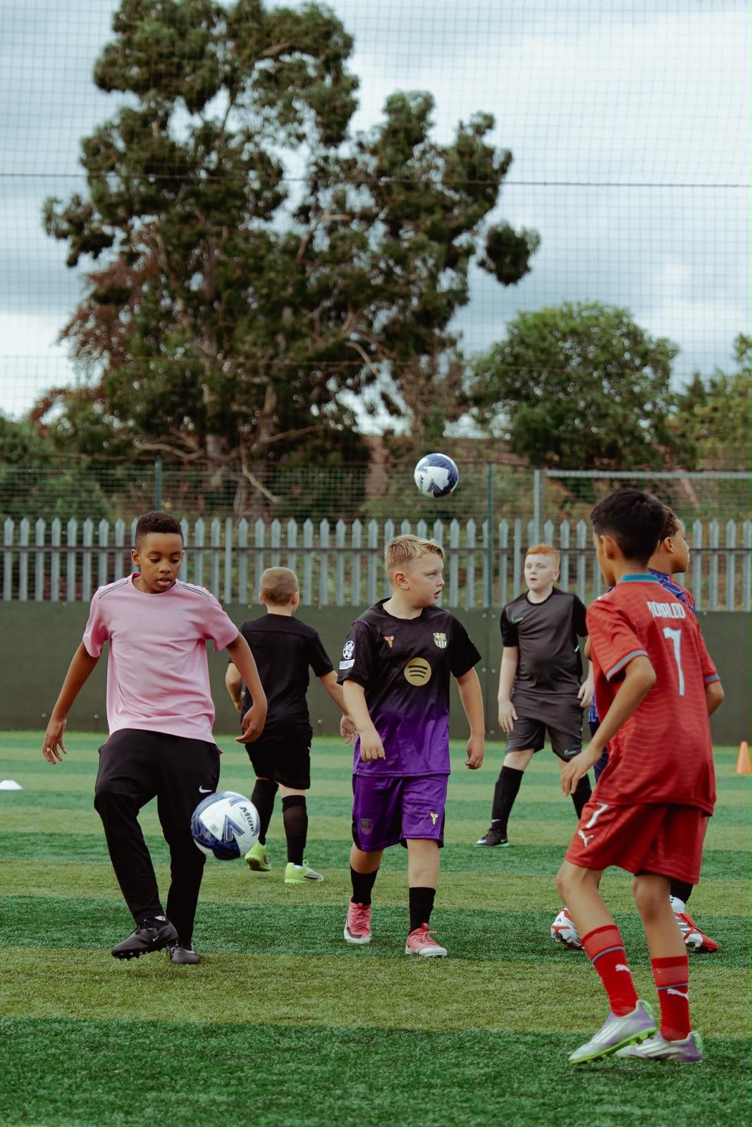 Group of young footballers contesting the ball mid-air